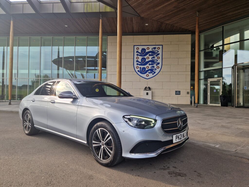 A silver Mercedes E-Class outside St George's Park, the England football training centre