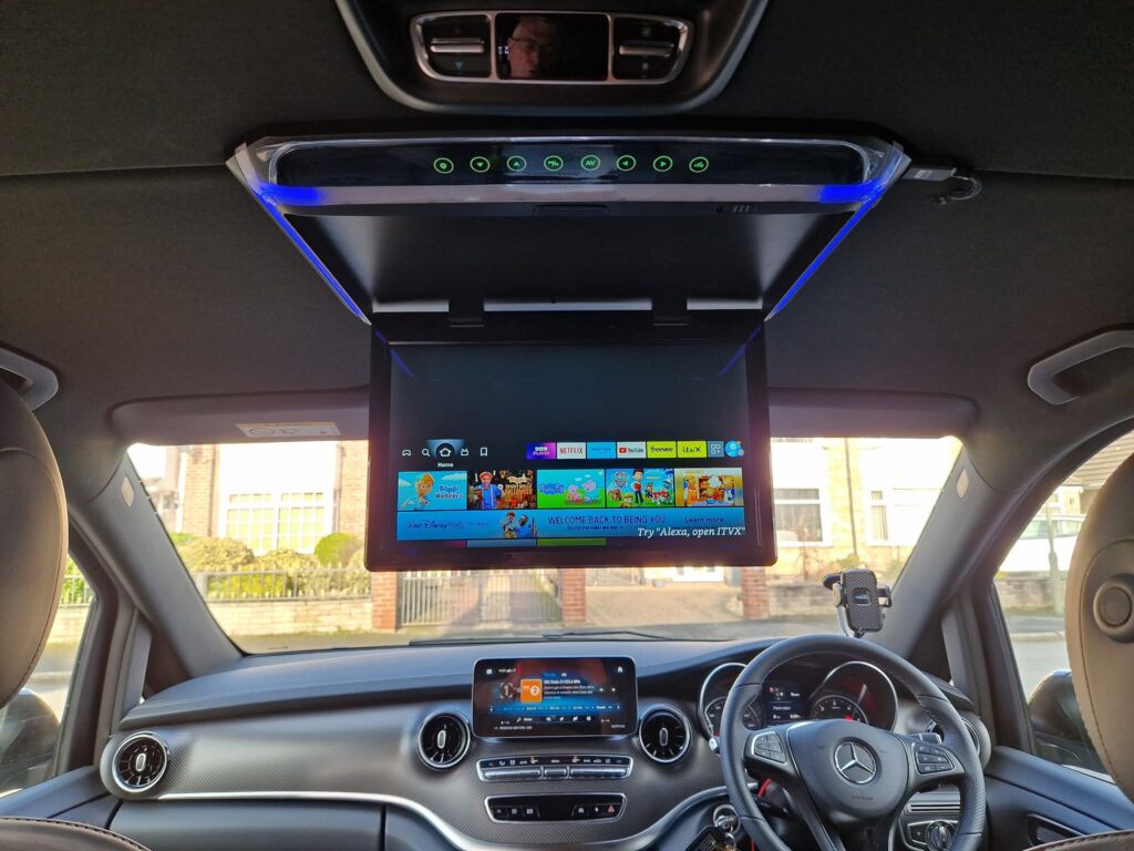 Inside a Mercedes V-Class, with a fold-down entertainment screen for rear passengers