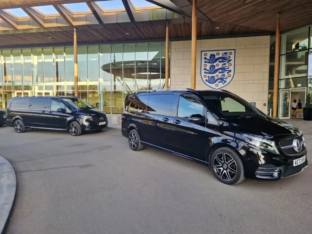 Two black Mercedes V-Class at a venue entrance