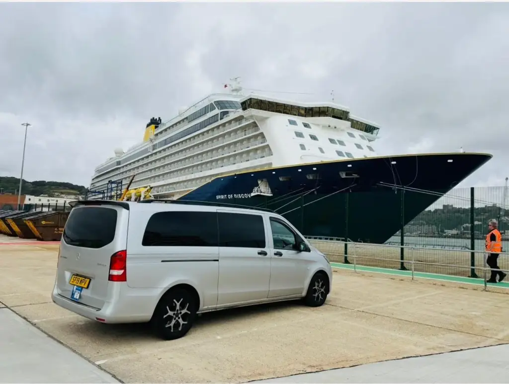 A silver Mercedes Vito at Dover beside the Spirit of Discovery